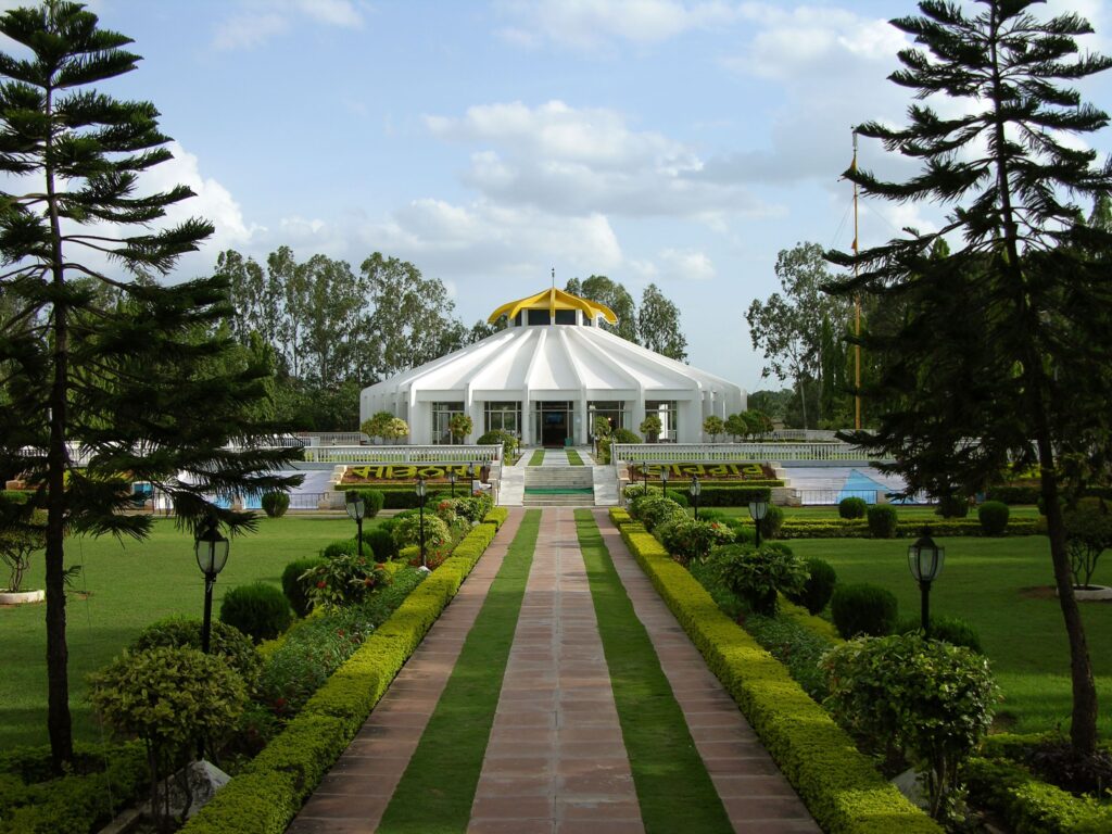 Beautiful gurudwara surrounded by lush gardens in Hyderabad, India, under a clear summer sky.